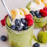Two jars of matcha overnight oats topped with fruit and yogurt