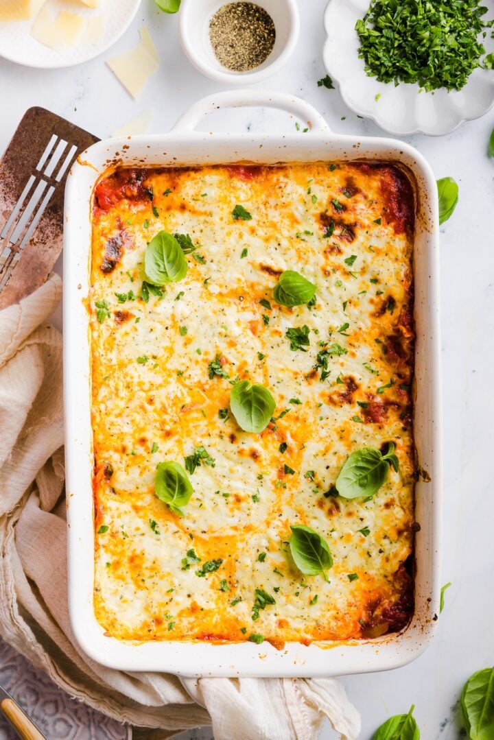 Birdseye photo of a cheesy, lazy, high protein lasagna garnished with fresh basil leaves