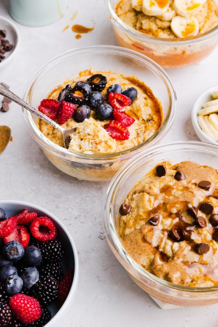 Close-up photo of protein pancake bowls in glass bowls, with different toppings