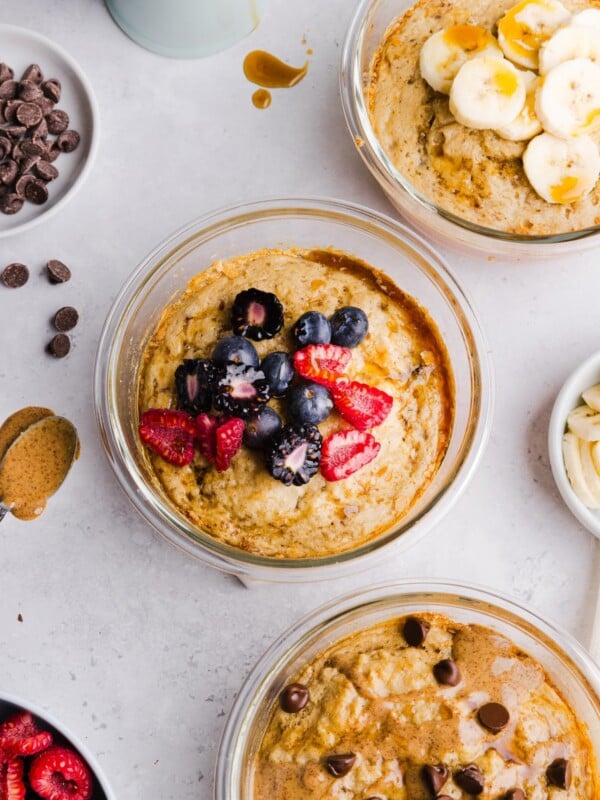 Protein pancake bowls with difference toppings arranges on a grey marble counter