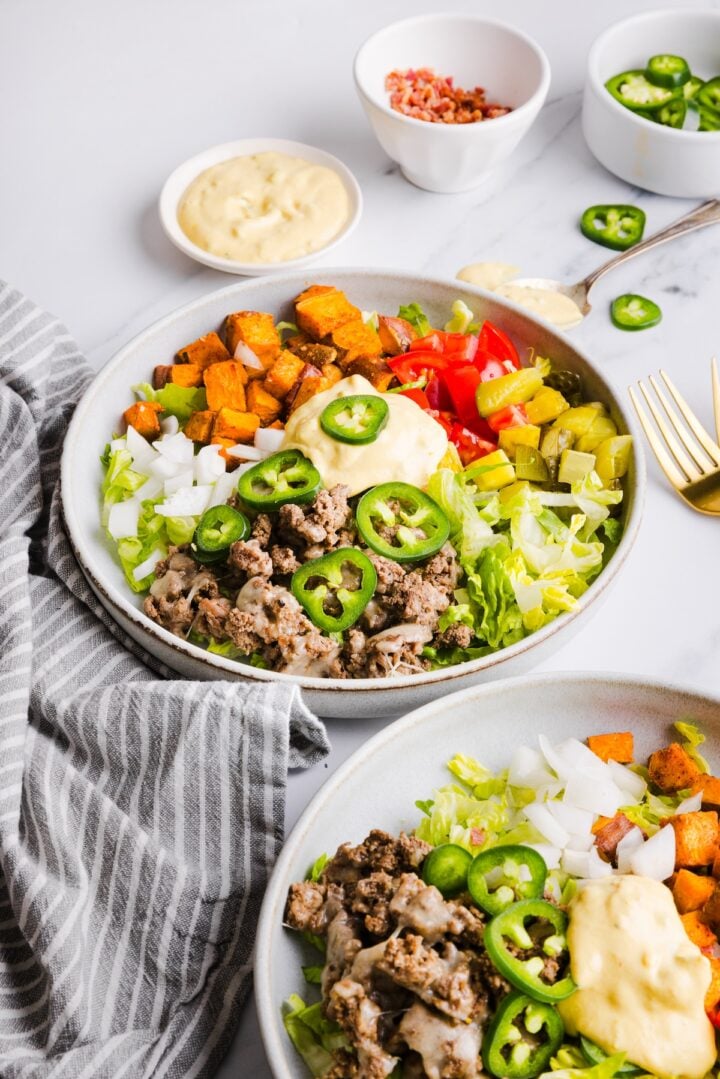 3/4 angle photo of two sweet potato burger bowls on a white marble counter