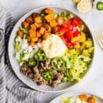 Overhead photo of two sweet potato burger bowls with healthy big mac sauce and other toppings