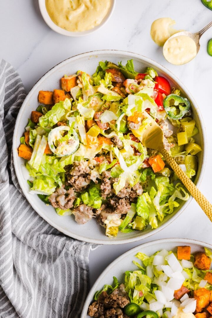 Sweet potato burger bowl mixed in a bowl with a gold fork