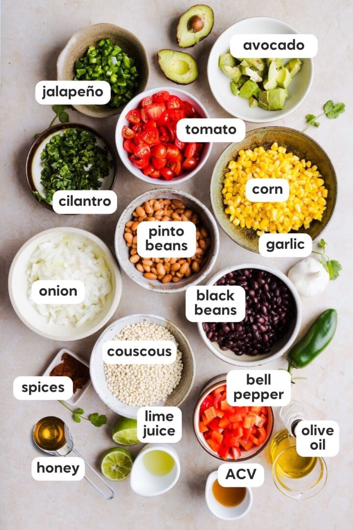 Ingredients for cowboy caviar couscous salad displayed in small boys on a kitchen counter