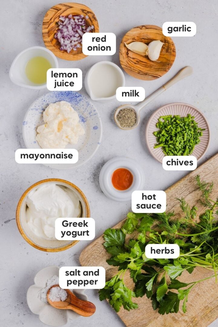 Labeled overhead photo of ingredients for green goddess ranch on a grey kitchen counter
