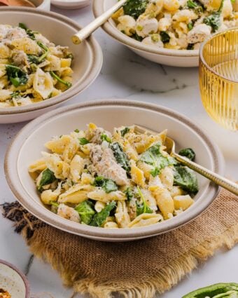 A few small bowls filled with one-pot chicken and artichoke pasta