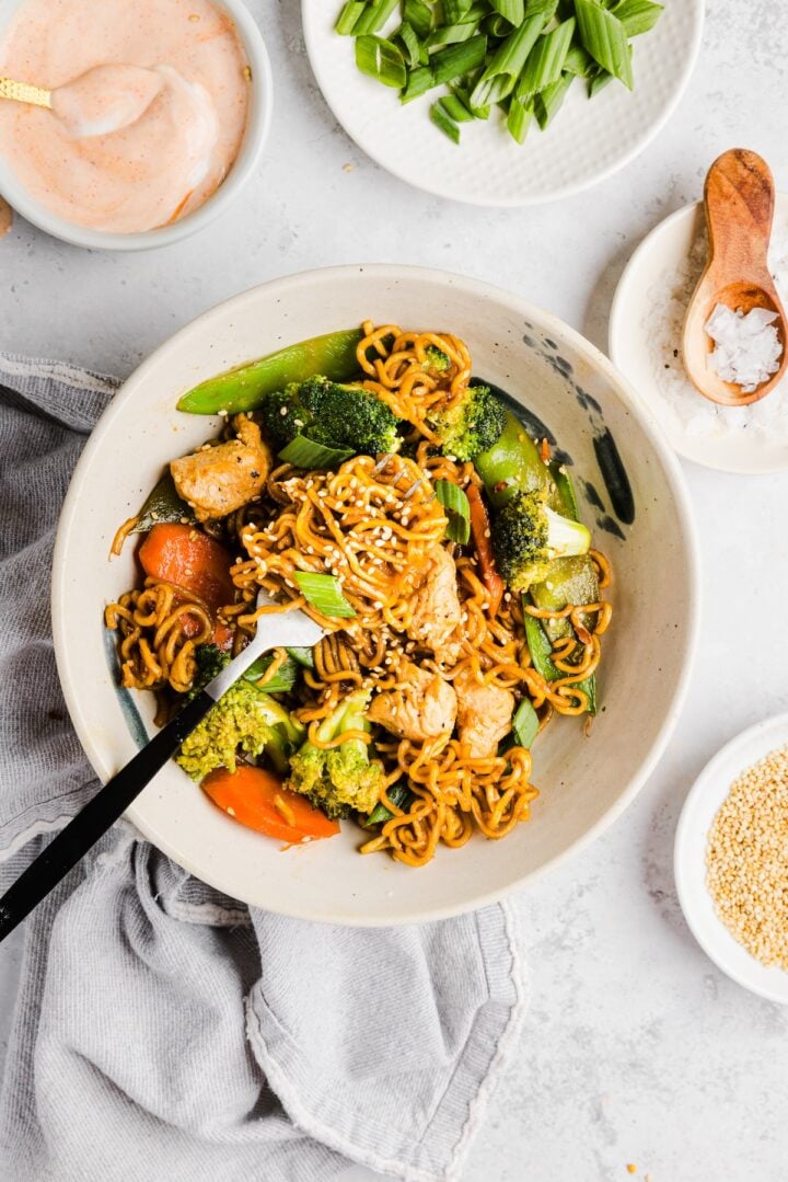 Small bowl of teriyaki chicken and noodles with noodles twisted around the fork