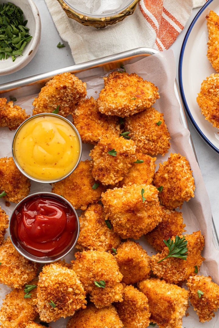 Overhead photo of baked, crispy, homemade panko chicken nuggets with mustard and ketchup