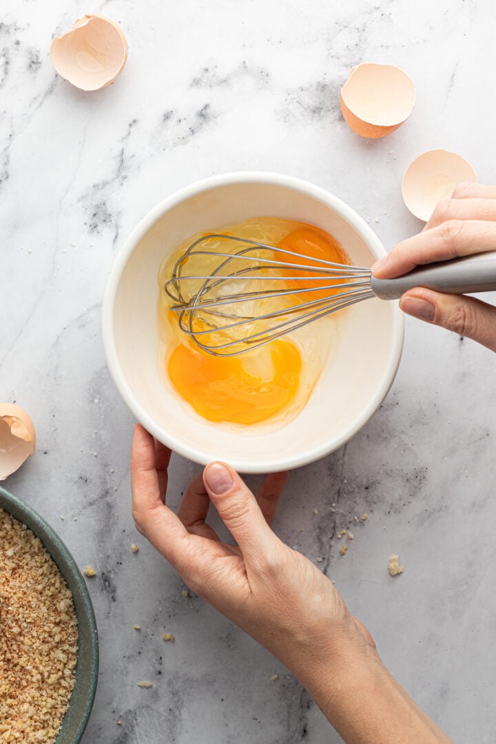 Whisked eggs in a small white bowl.
