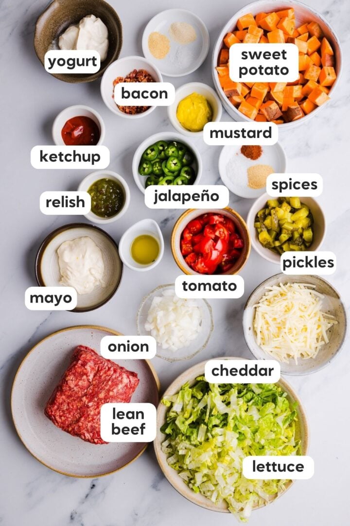 Labeled ingredients for sweet potato burger bowl displayed in small bowls on a white kitchen counter