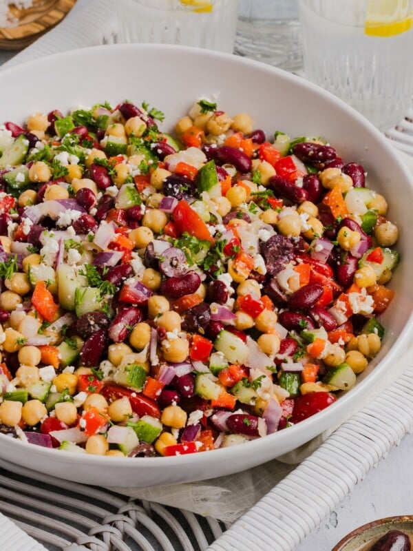 Greek bean salad mixed in a large white bowl