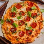 Overhead photo of Greek yogurt pizza crust topped with cheese, pepperoni, and basil