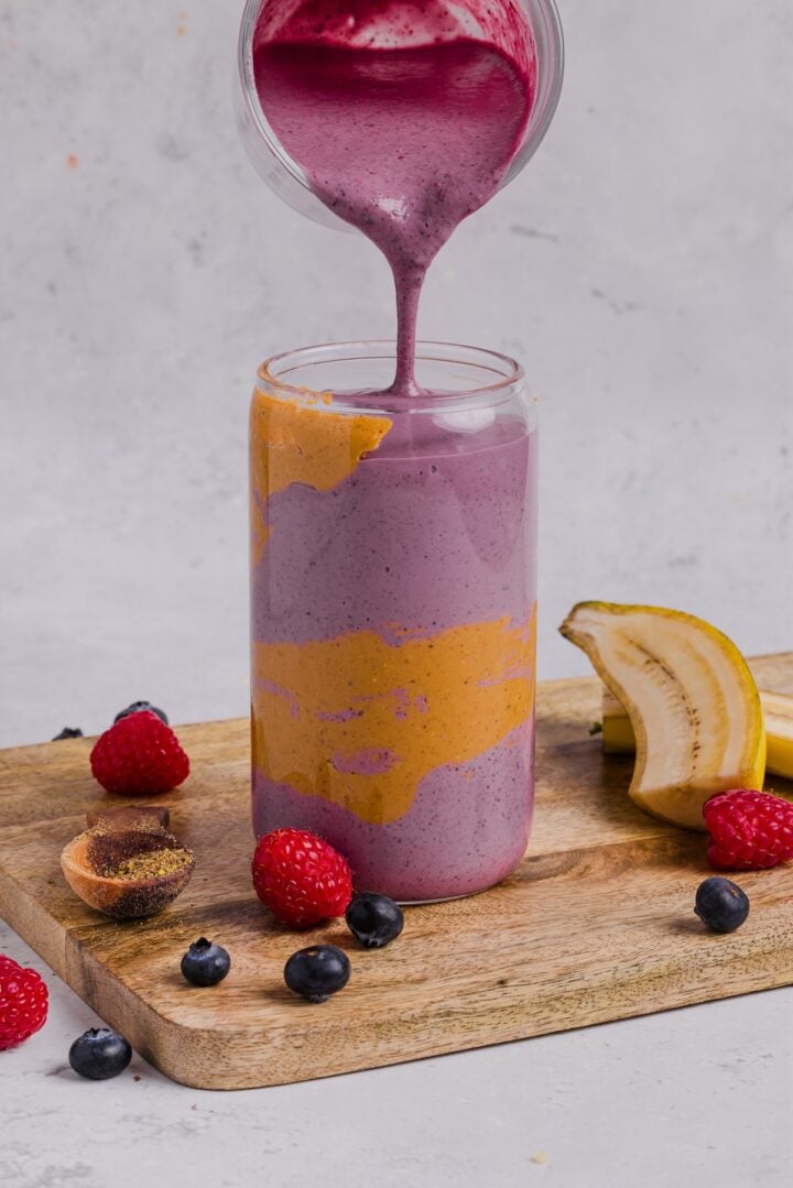 Smoothie being poured into a tall glass