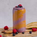 Peanut butter berry smoothie in a tall glass with peanut butter swirled in the glass