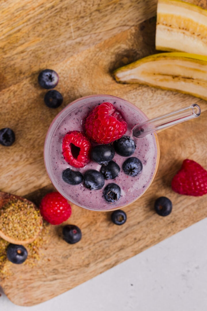 Overhead photo of a peanut butter berry smoothie in a glass