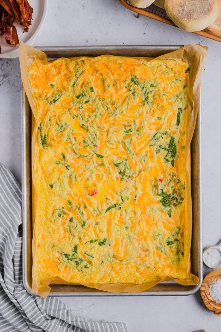 Baked sheet pan eggs with cottage cheese in a large parchment-lined sheet pan