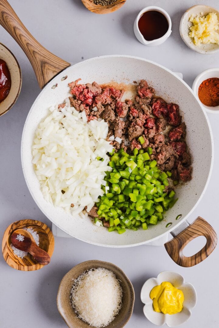 Veggies added to crumbled ground beef in a large pan