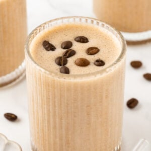 Etched glass containing coffee protein shake, garnished with coffee beans