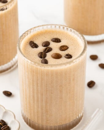 Etched glass containing coffee protein shake, garnished with coffee beans