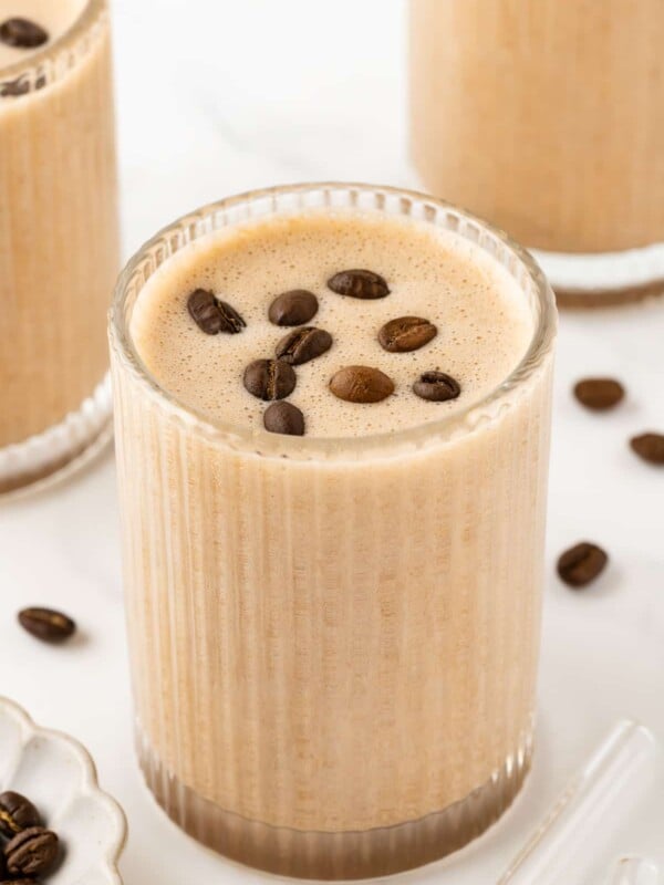 Etched glass containing coffee protein shake, garnished with coffee beans