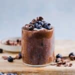 Chocolate chia pudding in a glass jar, topped with yogurt and fresh blueberries