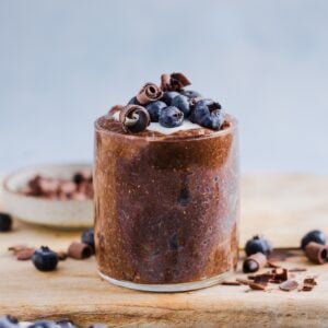 Chocolate chia pudding in a glass jar, topped with yogurt and fresh blueberries
