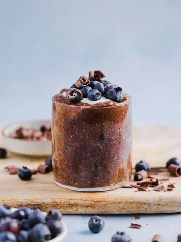 Chocolate chia pudding in a glass jar, topped with yogurt and fresh blueberries