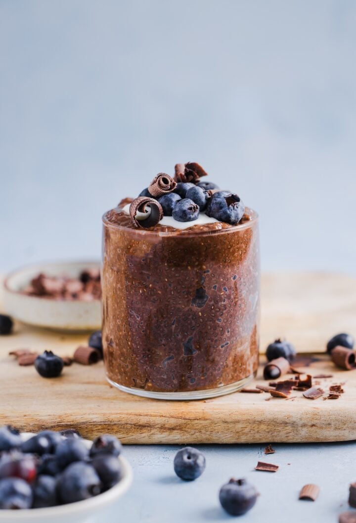 Chocolate chia pudding in a glass jar, topped with yogurt and fresh blueberries