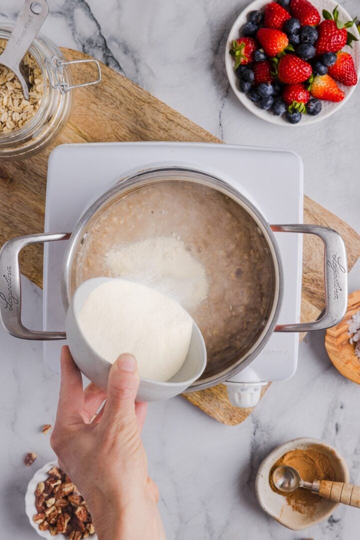 Protein powder added to a pot with oatmeal