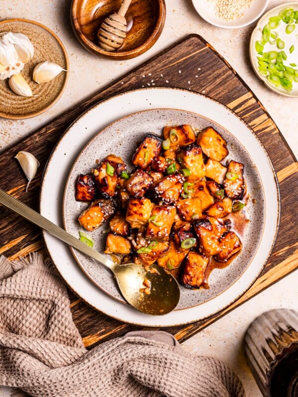 White bowl with air fryer salmon bites, topped with sliced green onion.