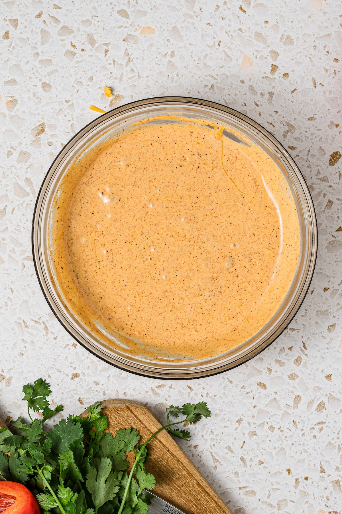 High-protein cottage cheese queso melted and blended in a microwave-safe glass dish.