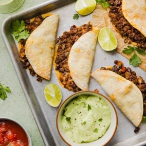 Crispy beef tacos with avocado lime crema on a sheet pan