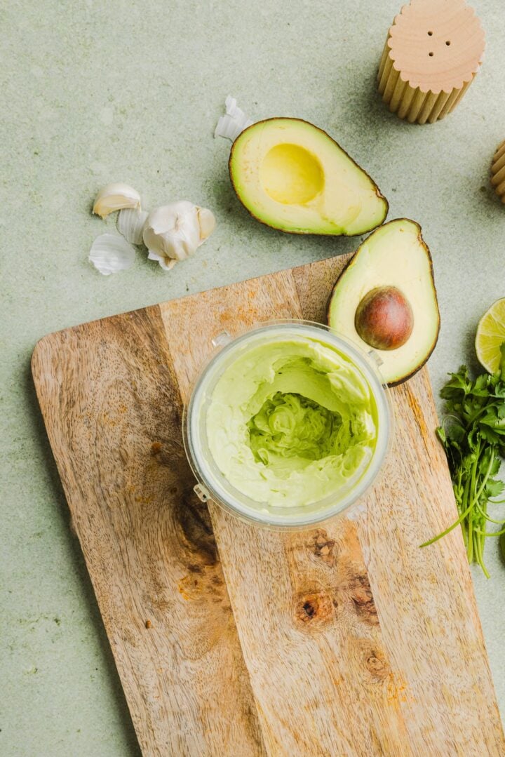 Avocado lime crema blended in a blender cup.
