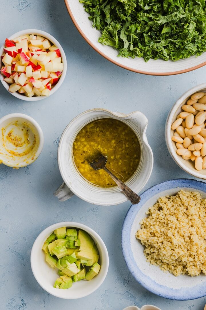 Honey mustard dressing for kale white bean salad whisked in a small white pour cup.