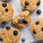 Whole wheat blueberry muffins on a grey marble counter top.