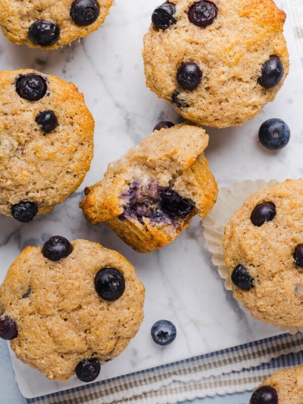 Whole wheat blueberry muffins on a grey marble counter top.