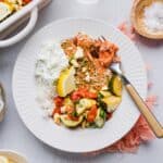 Baked greek salmon bowls with roasted vegetables and tzatziki.
