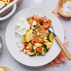 Baked greek salmon bowls with roasted vegetables and tzatziki.