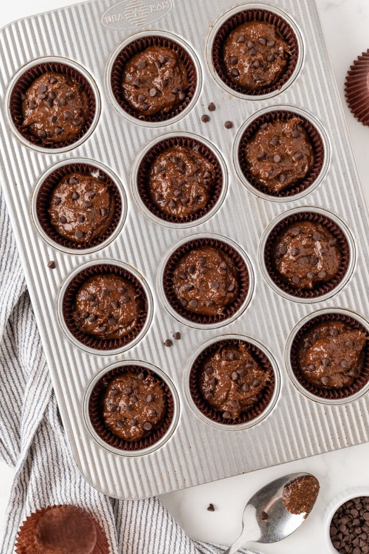 Chocolate banana muffins raw in a parchment-lined muffin pan.