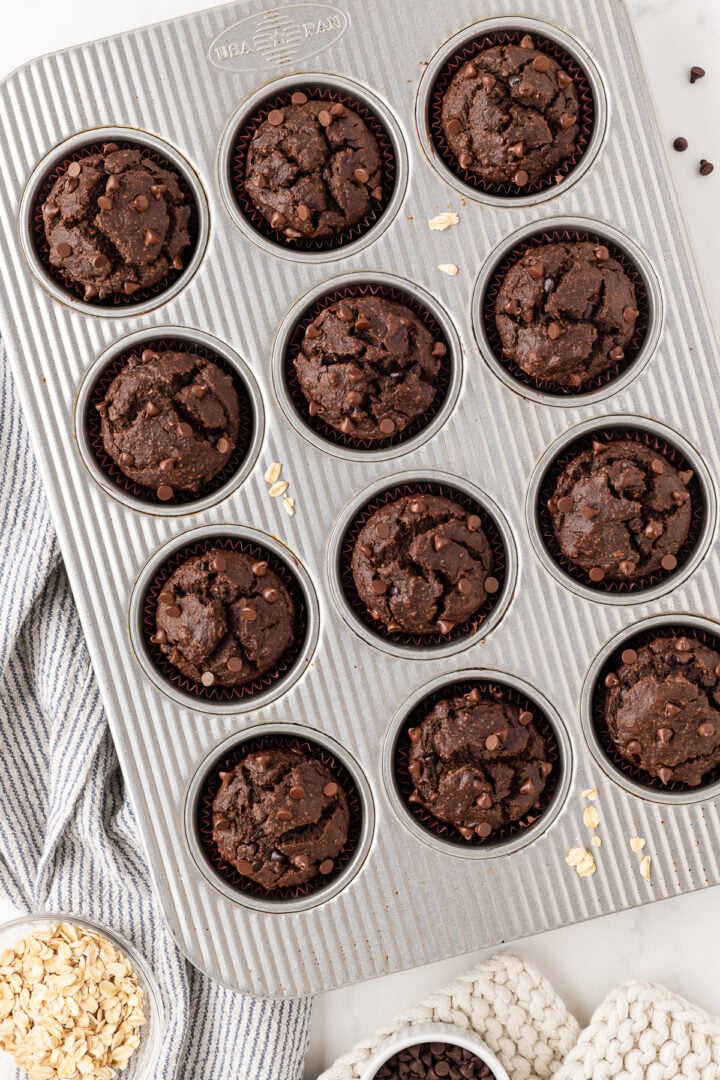 Baked chocolate banana muffins in a muffin pan.
