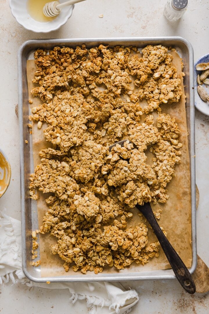 Peanut butter granola cooled and broken into chunks in a pan.