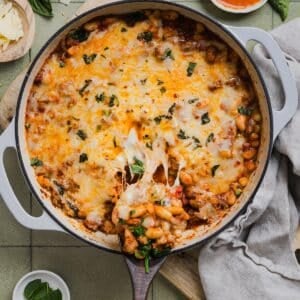 One-pan pizza beans topped with cheese and parsley.
