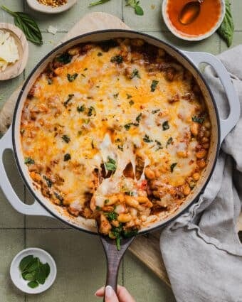 One-pan pizza beans topped with cheese and parsley.
