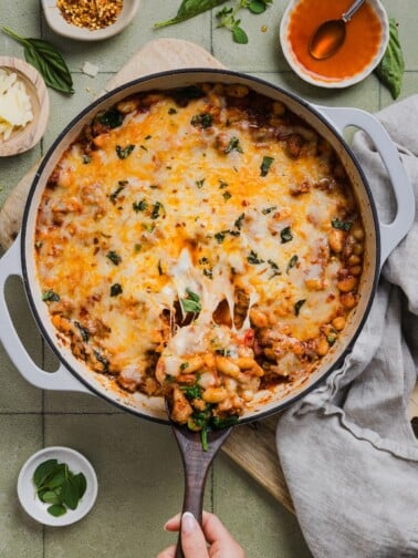 One-pan pizza beans topped with cheese and parsley.