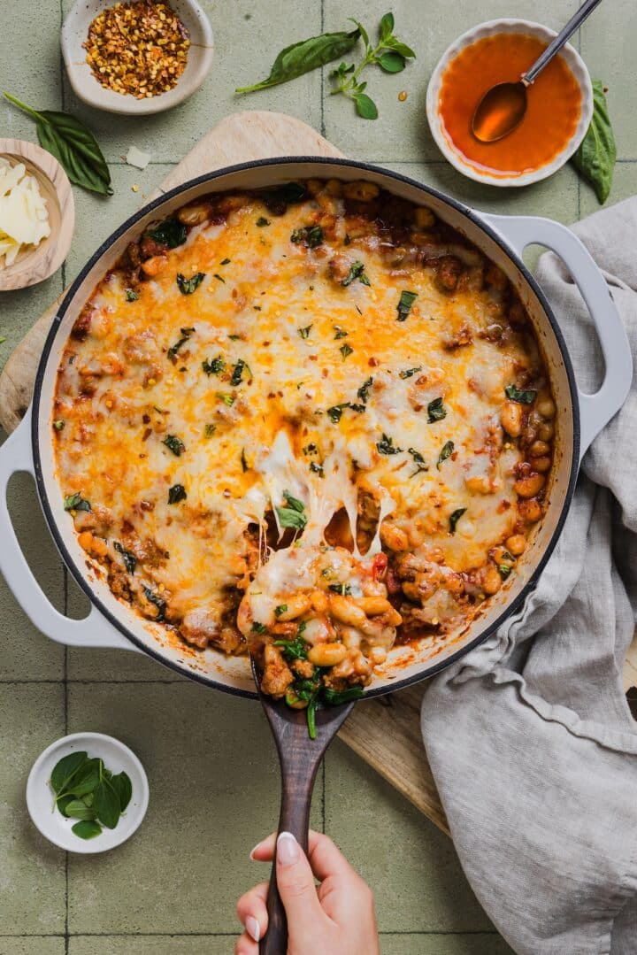 One-pan pizza beans topped with cheese and parsley.
