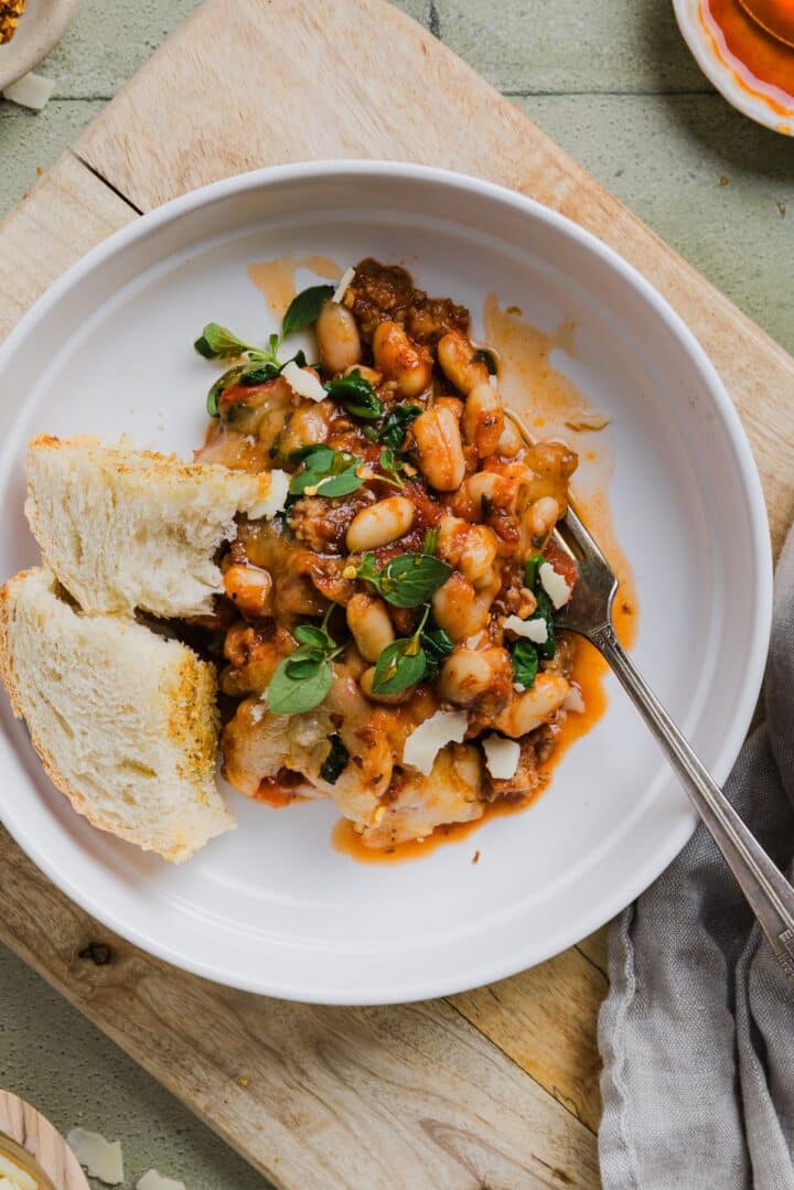 Pizza beans in a bowl with garlic bread.