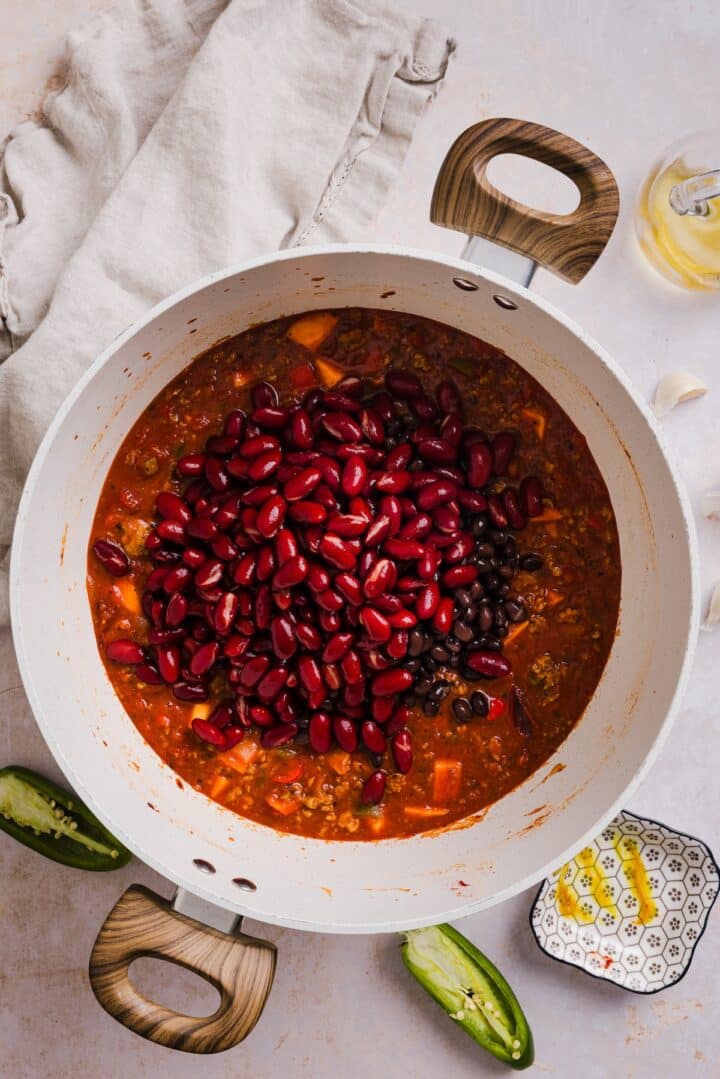 Beans added to turkey chili in a large pot.
