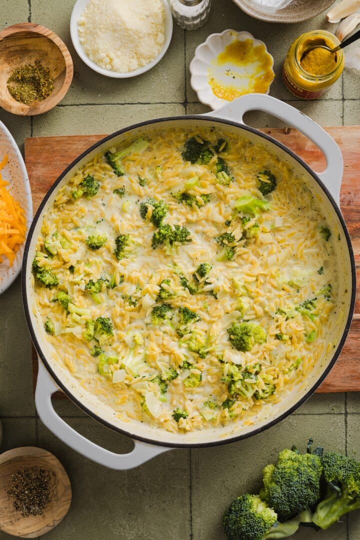Broccoli cheddar orzo simmering in a braiser pan.