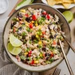 Southwest chicken salad in a serving bowl with lime wedges.