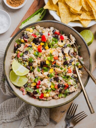 Southwest chicken salad in a serving bowl with lime wedges.